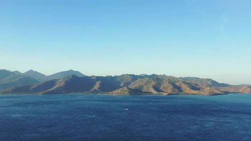 Wide angle above island view of a white sand paradise beach and turquoise sea background in vibrant
