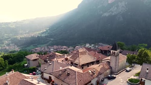 Aerial ascending shot to reveal a small historic town in the Italian Alps