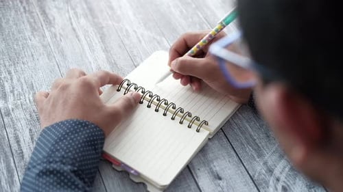 Close Up of Man Hand Writing on Notepad
