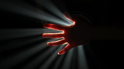 Hand Reaching into Beams of Light in the Dark