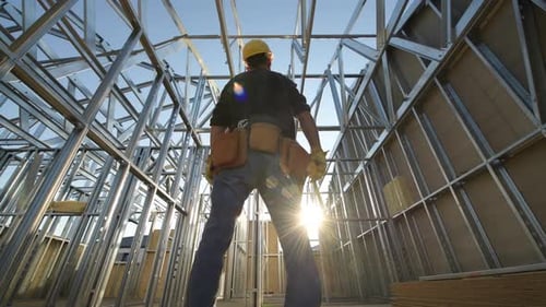 Construction Worker Inside Steel Frame Building on Sunny Day