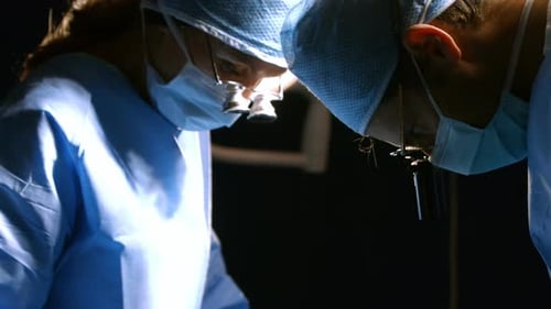 Surgeons performing operation in operation room