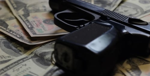 Dólares y pistola girando de cerca