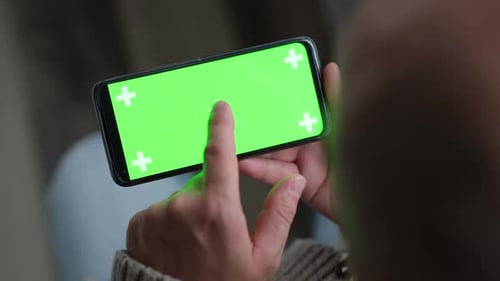 Close Up of Man Hand is Holding Chroma Key Green Screen in Horizontal Position Touching Swiping