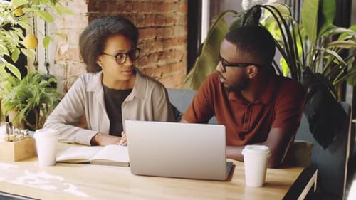 Afro-American Coworkers Discussing Business Project in Cafe