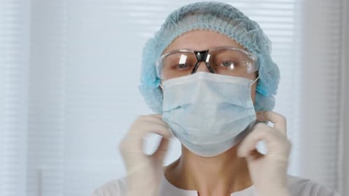 Ärztin Frau In Spezieller medizinischer Kleidung In einer Schutzmaske auf Gesicht