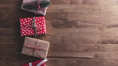 Top view of Christmas gift boxes moving on wood table background