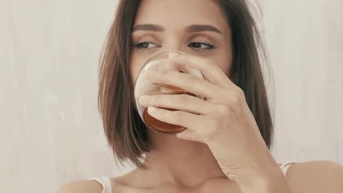Portrait d'une jeune belle mannequin brune posant dans un intérieur blanc