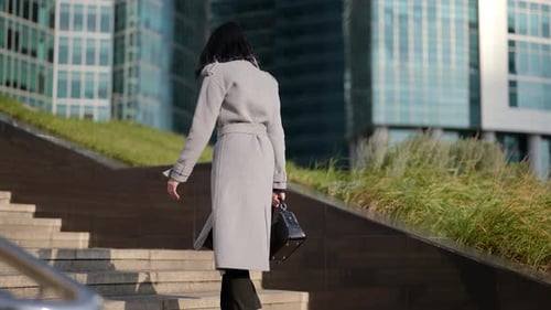 Successful and Confident Woman is Walking to Work Rising Up on Stair of Modern Office Building