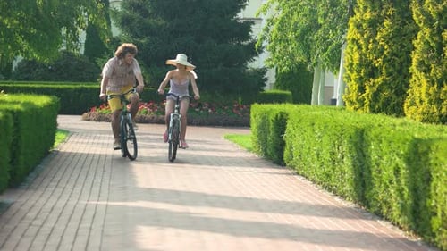 Young Adults Riding Bicycles on Path in Park