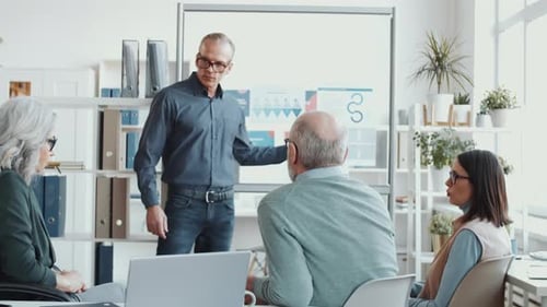 Man Leading Office Presentation for Small Team