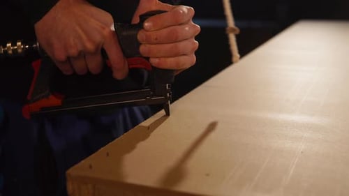 Man Using Staple Gun in Workplace