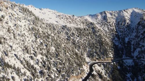 Aerial of a road through the mountains after a snow