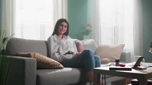 Young Woman Is Sitting On Sofa