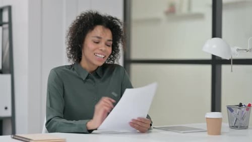 Woman Excited about Documents in Modern Office