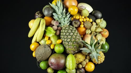 Rotating Exotic Fruits On Black Background Top View.