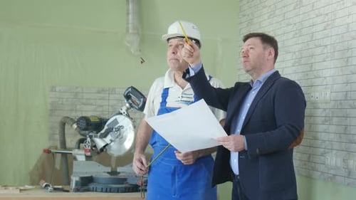 Zwei Bauarbeiter kommunizieren und sprechen von der Reparatur eines neuen Hauses