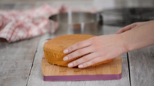 Cutting Sponge Cake in Kitchen at Home