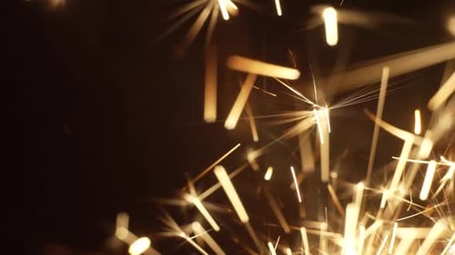 Bright Sparks of Sparkler Shining Vividly in Dark Room