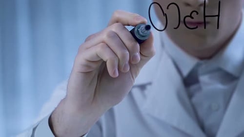 Apotheker schreibt chemische Formel auf transparentem Karton, Herstellung von Medikamenten