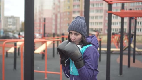 Woman in Boxing Gloves Boxing on the Street Training Ground Fight with Shadow