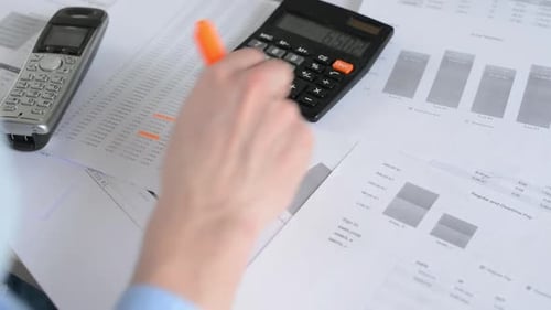 Mann arbeitet im Büro - Schreiben auf Papier mit Textmarker - Schuss über die Schulter