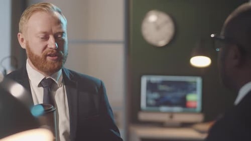 Businessman with Coffee Talking with Coworker in Office