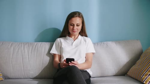 Woman Using Smartphone While Sitting on Couch