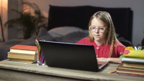 Lachendes Schulmädchen-Surfnetz auf Laptop zu Hause