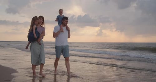 Young Family of Four Walking Down the Beach