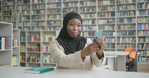Woman Using Smartphone in Library Setting