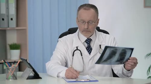 General Practitioner Examining X-Ray, Filling Medical Form for Hospitalization