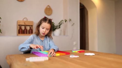 Little girl playing with big silicone popit, simple dimple, bubble fidget toy