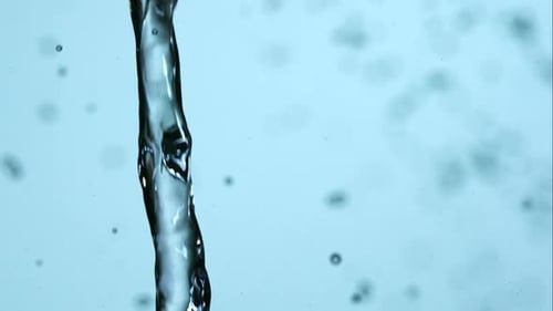 Clear Water Pouring with Splash on Blue Background