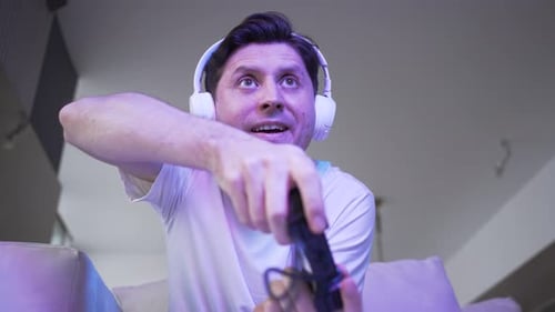 Man Playing Video Game at Home with Headphones