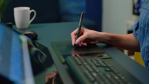 Woman Using Stylus on a Graphics Tablet