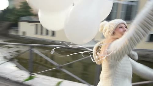 Woman Walking with Balloons on City Sidewalk