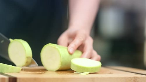 Slicing Fresh Zucchini with Sharp Silver Knife
