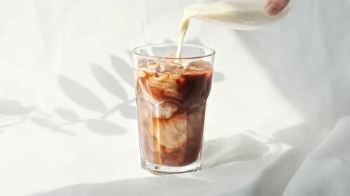Pouring Fresh Milk into Iced Coffee