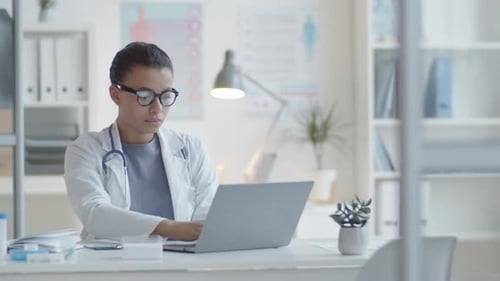 Female Doctor Working on Laptop in Office