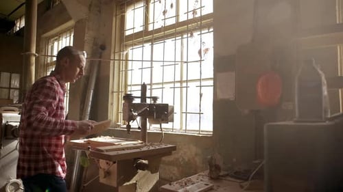 Man Operating Drill Press in Workshop