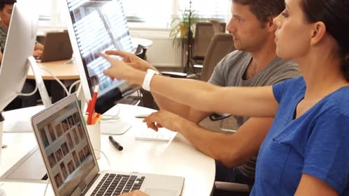Coworkers Working Together at Desk in Modern Office