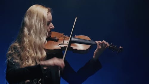 Young Beautiful Woman Playing a Melody on Violin. Smoky Dark Studio