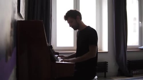 Man Plays Piano in Bright Room