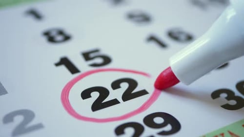 Marking Date on a Calendar with a Red Marker