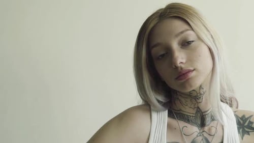 Blonde Woman with Tattoos Looking into Camera