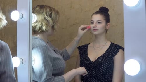 Makeup Artist Applying Foundation to Young Woman's Face