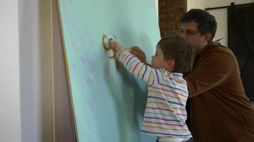 Father and Child Painting Together on Canvas