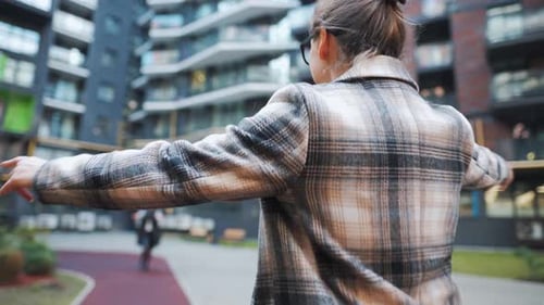 Two Women Embracing in Modern City Courtyard