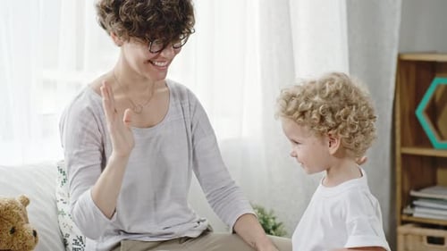 Mother Teaching Toddler Boy to High-Five